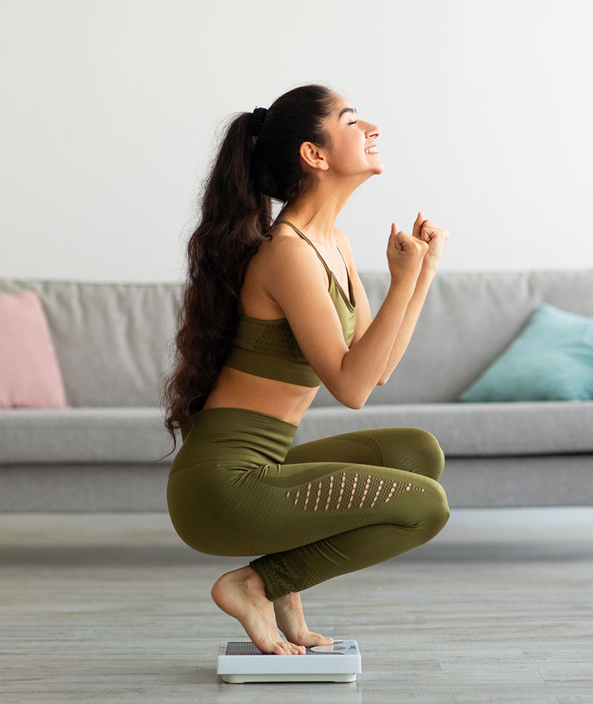 excited-woman-sitting-on-scale